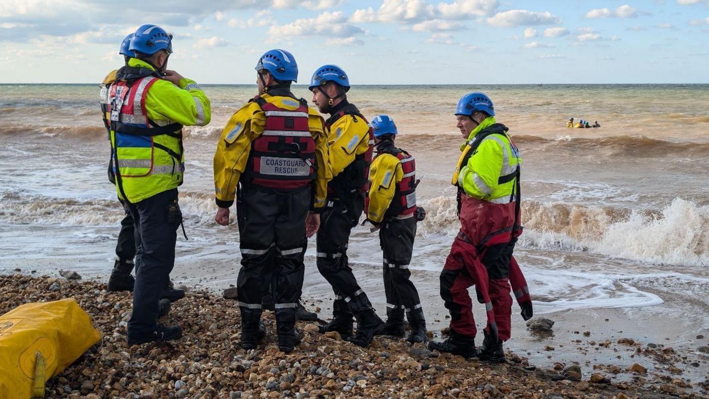 Members of the coastguard team gather on the beach.