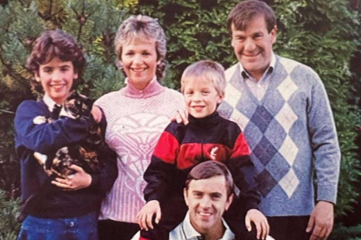Ronnie (far right), Rob (bottom centre), with their son Lloyd on his shoulders. Dianne (middle) wears a pink jumper and their daughter Katie wears a navy jumper and holds their pet cat. 