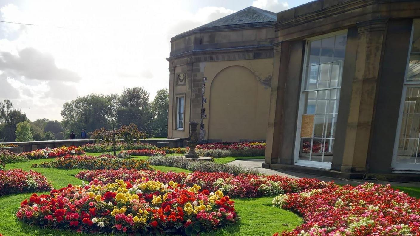 Orangery surrounded by flowers in garden