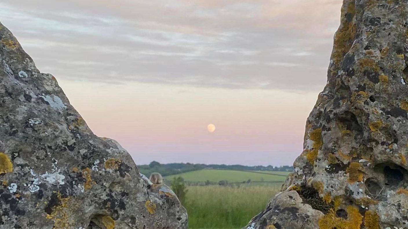 Sun in the background with rollright stone in foreground