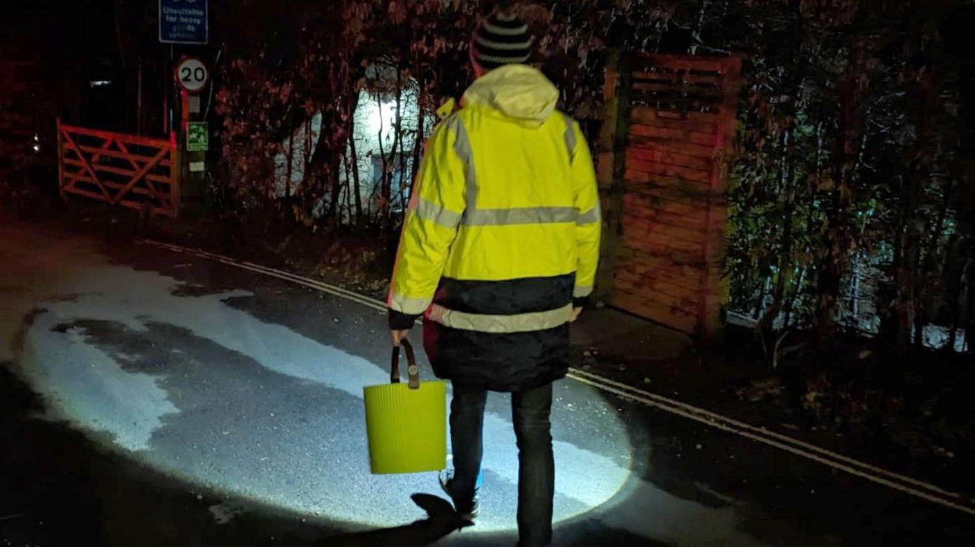 Undated handout file photo from Charlcombe Toad Rescue of a volunteer during the toad patrol in Charlcombe, near Bath.