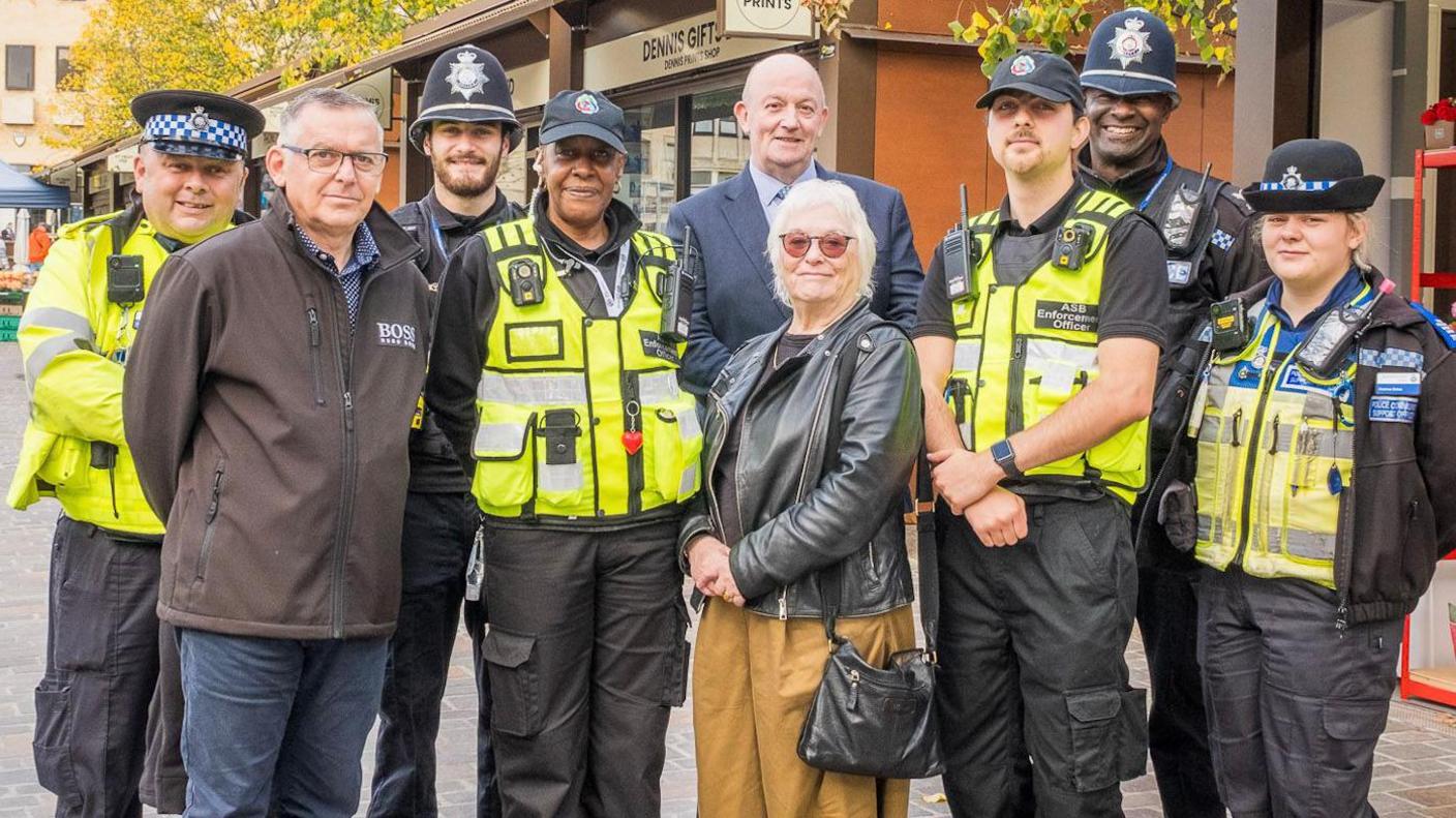 From left to right: Scott Potter - Police Community Support Officer (PCSO), Gary Crook - Community Safety Operations Manager, PC Adam Perch, Cheryl Richards - Anti Social Behaviour Enforcement Officer, Danielle Stone - Northamptonshire Police, Fire and Crime Commissioner, Cllr Charlie Hastie - Cabinet Member for Housing and Communities , George Harper -  Anti Social Behaviour Enforcement Officer, PS Rodney Williams, Catriona Eales - PCSO, standing outside all looking at the camera