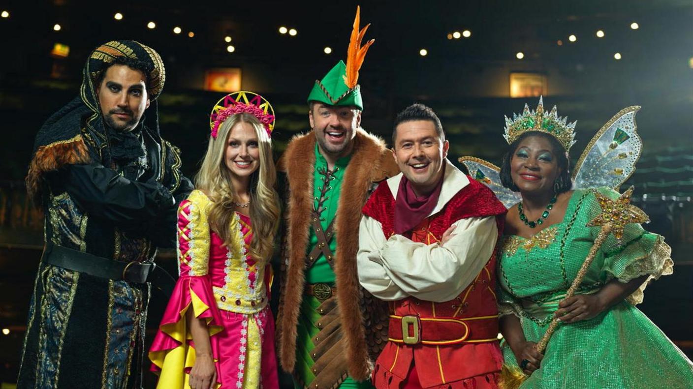 The cast of the Robin Hood panto in costume with Jason Manford and Ben Nickless in the middle smiling at the camera.