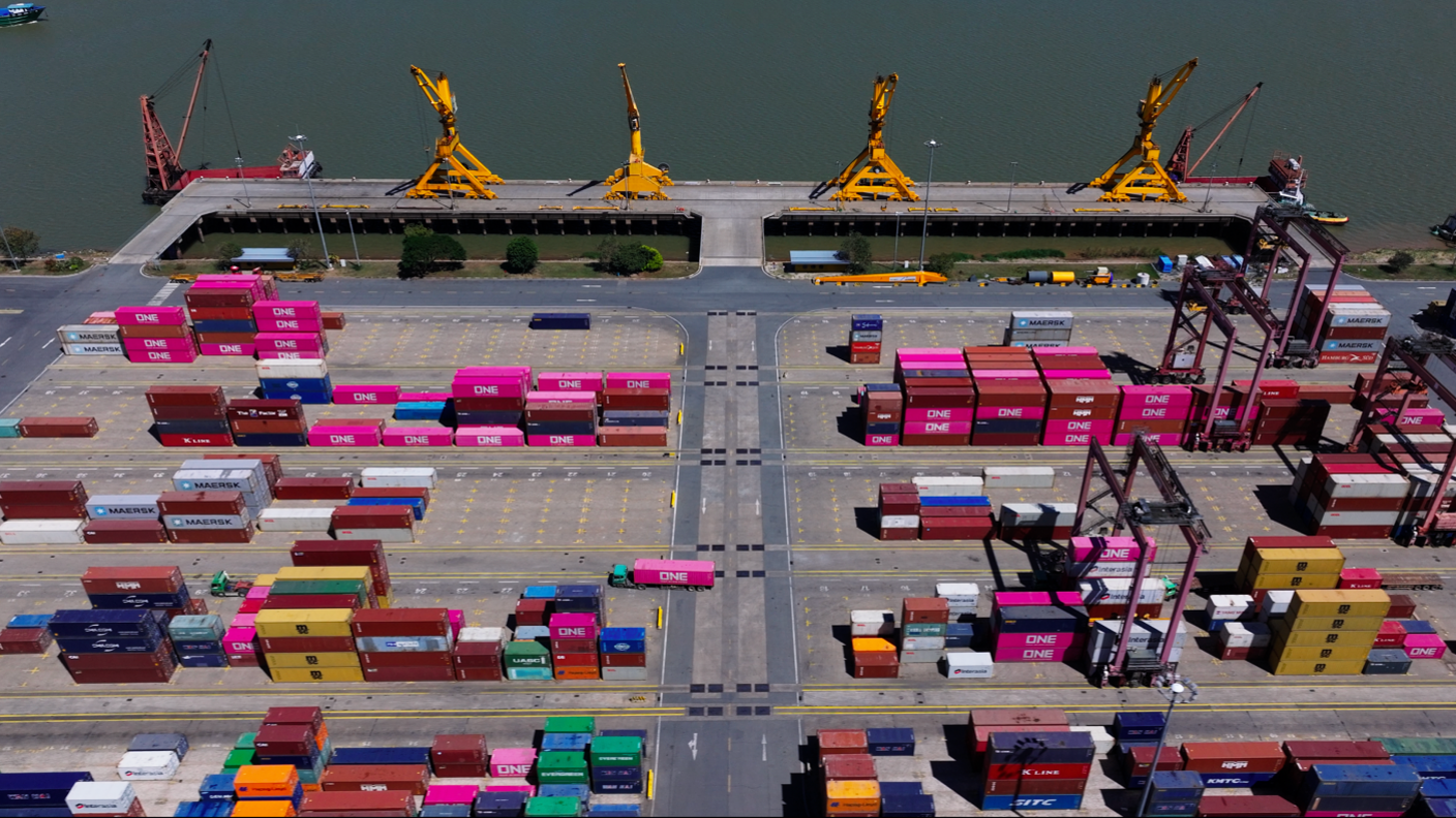 A port terminal in Cambodia shows pink and yellow containers