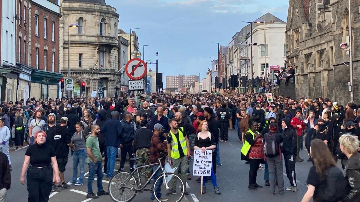 Hundreds of people stand on Old Market in Bristol as part of an anti-racism rally