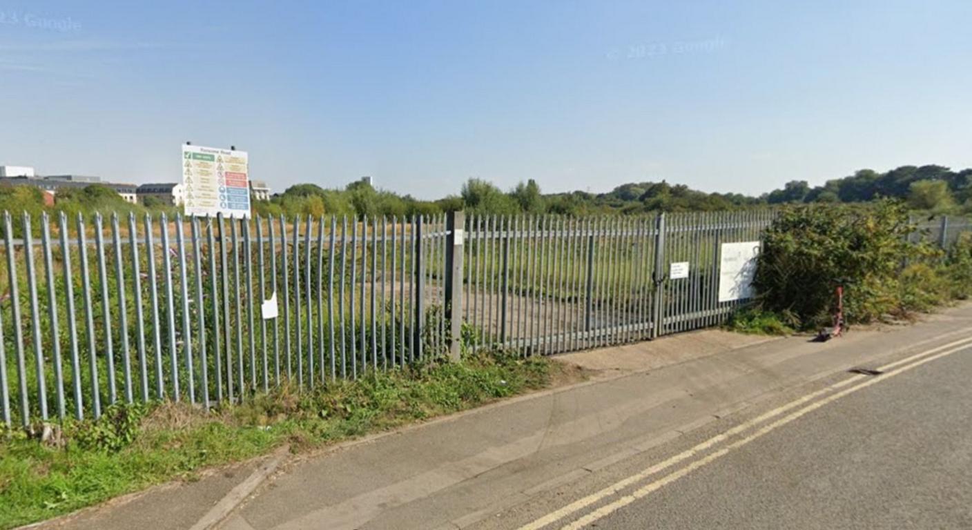 A metal fence surrounds a field