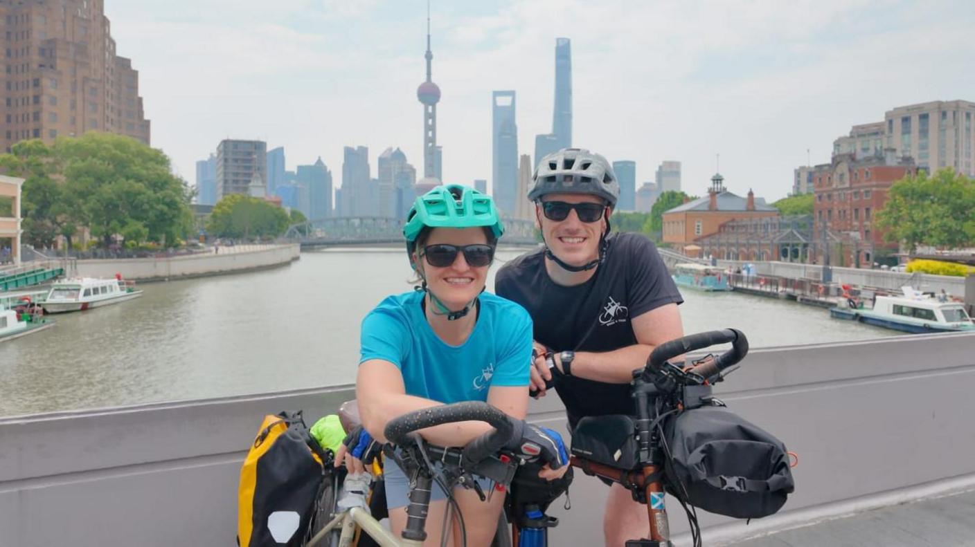 Jess Gray and Matt Kidd - the couple smile for the camera with their bikes in front of them, while on a bridge.