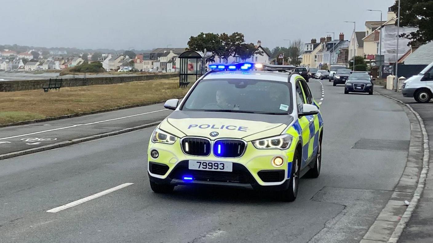 A police car with blue and white lights driving