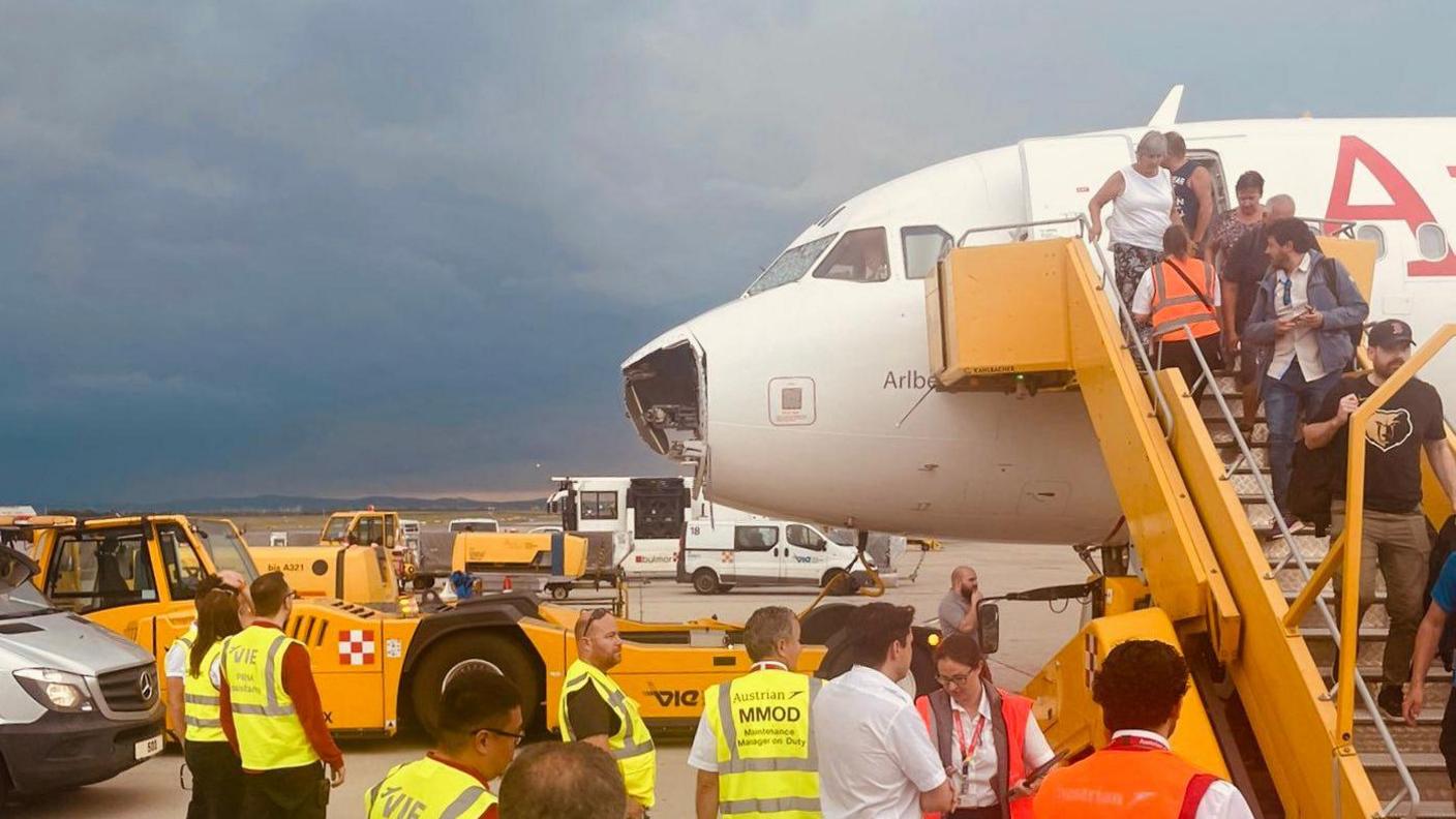 Passengers disembark the plane after the flight