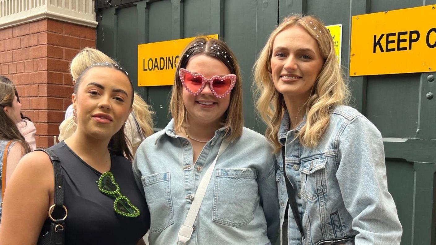 Three women standing together smiling