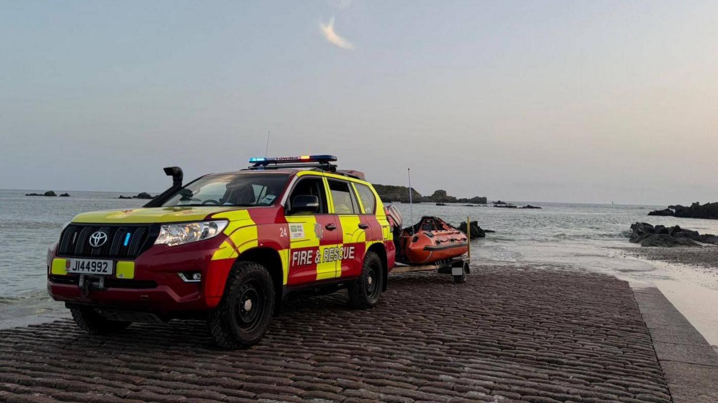 A picture from the scene showing a fire and rescue four by four on a slipway. A life boat is attached to a trailer on the vehicle.