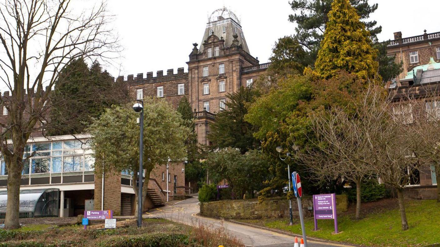 General view of County Hall in Matlock. There are trees in the foreground of the Grade-I listed building