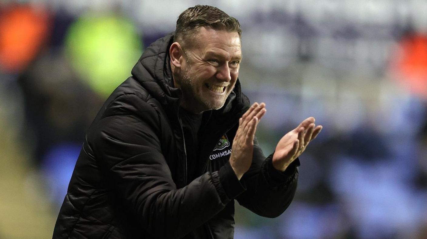 Northampton Town boss Kevin Nolan claps his hands to urge his team on against Reading