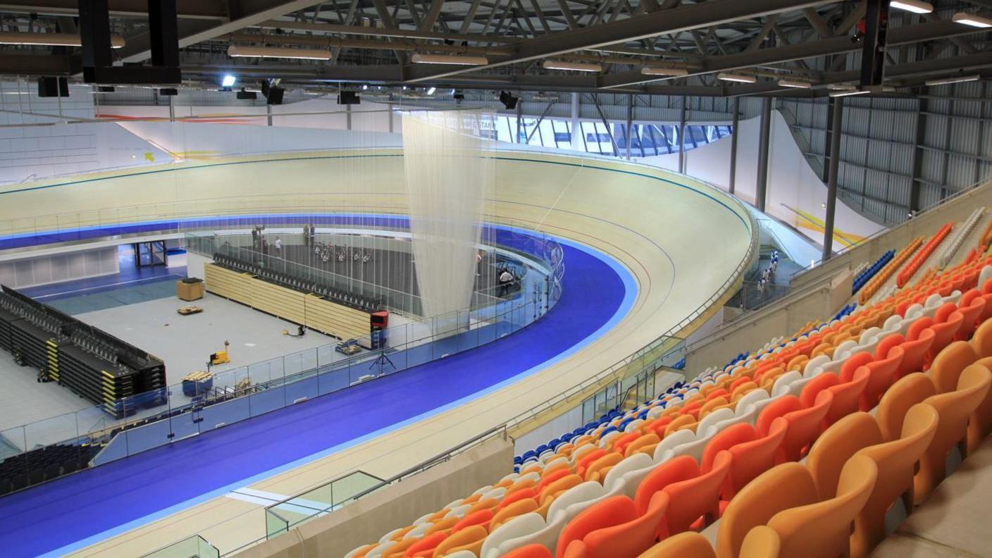 Inside Derby Arena. Orange, white and blue seats can be seen above the cycling velodrome.