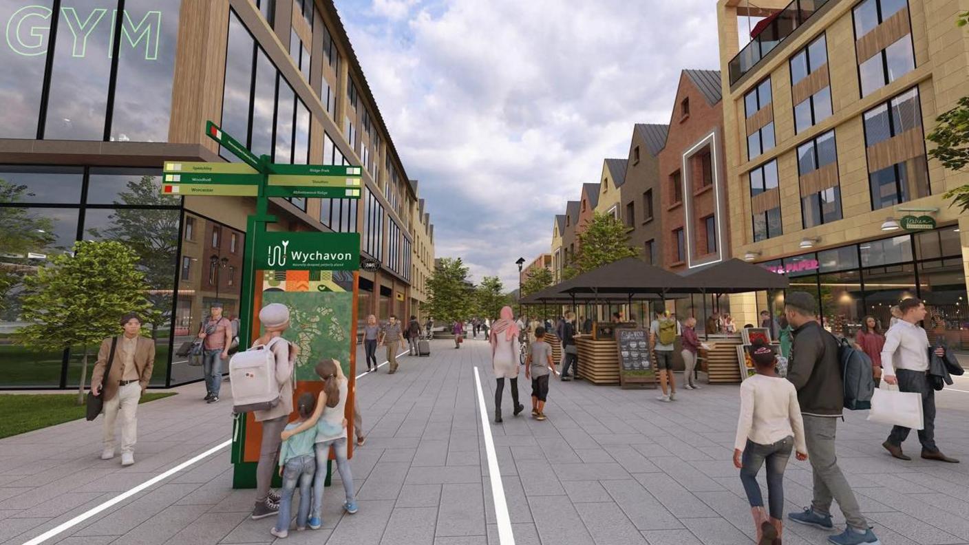The image shows a modern, pedestrian-only town centre with wide grey pavements and new buildings on both sides. People walk, shop and browse small market stalls under umbrellas.