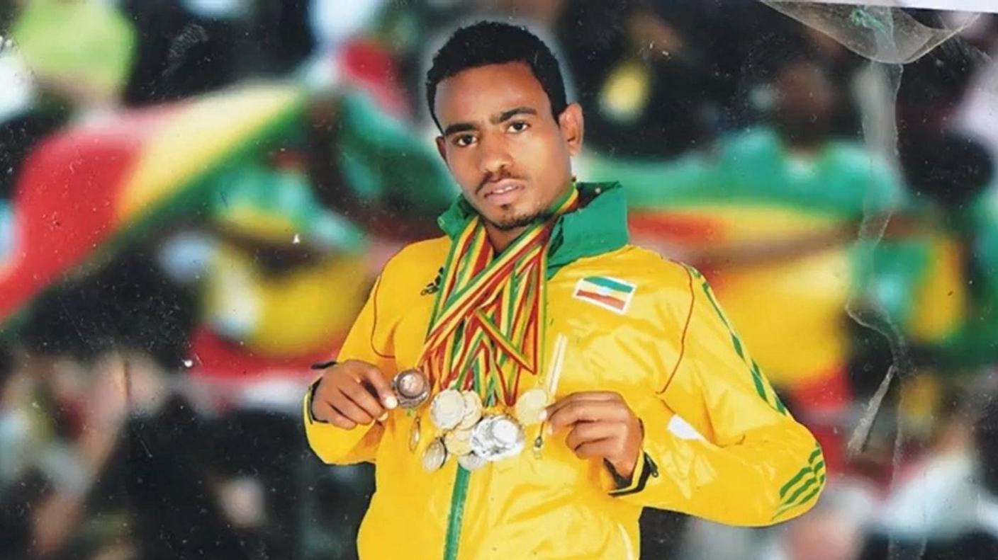 Redae Gebreyesus poses with medals he won in an Ethiopia tracksuit