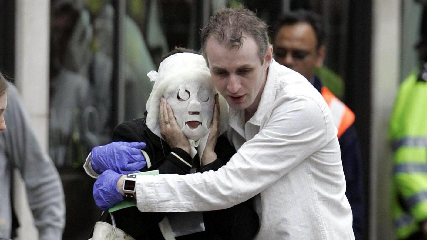Walking wounded people, including a woman with a burn treatment over her face, leaving Edgware Road tube station after a bomb detonated.