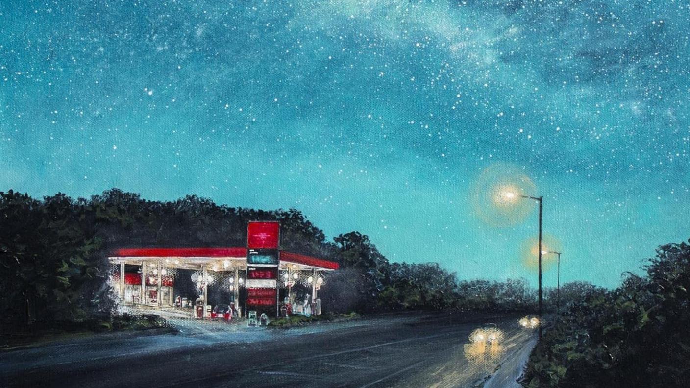 Close up of the painting. The painting shows the red Texaco petrol station on the side of the road. The painting shows a night sky. Two street lamps and two cars light up the painted road. 