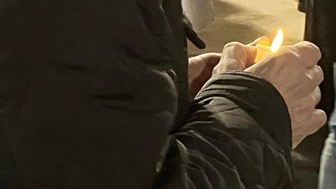 A woman in black coat holding a candle at the Derry vigil on Monday evening.