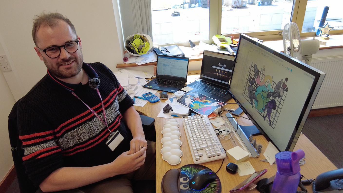 Design engineer Dominic Strange sitting at his desk with the design for one of this year's features on the screen 