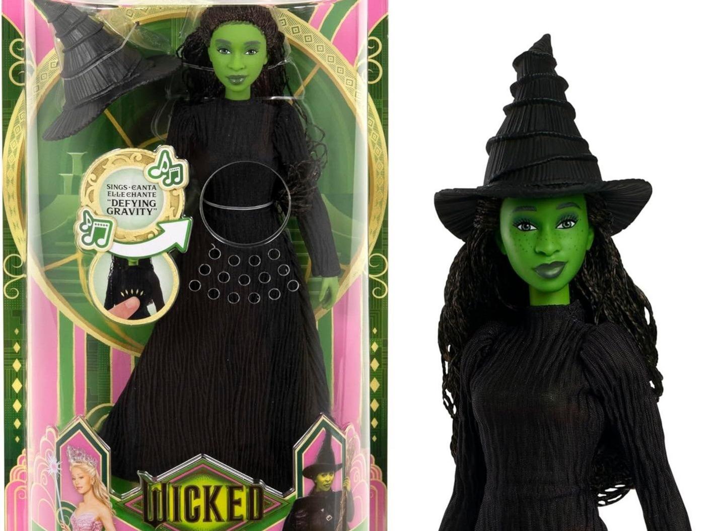 A singing Elphaba doll tied to the upcoming Wicked movie wearing black witch's clothes beside another doll in its packaging.