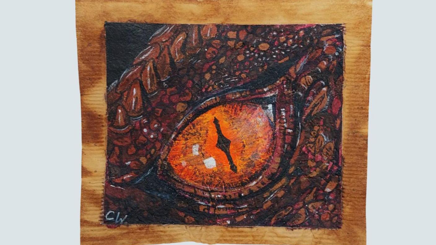 A close up painting of a dragon's eye on a teabag.