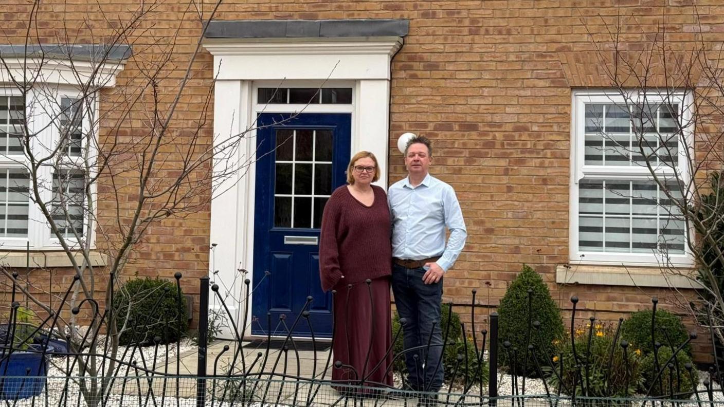 A couple stood in front of their newbuild house