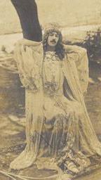 Henry Paget posing dressed in a wig and gown