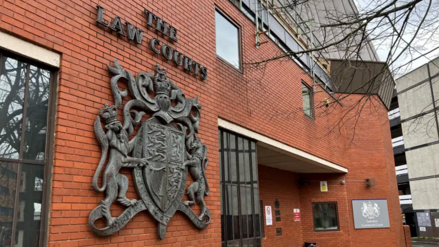 Red-brick exterior of Swindon Crown Court with 'the law courts' on the outside.