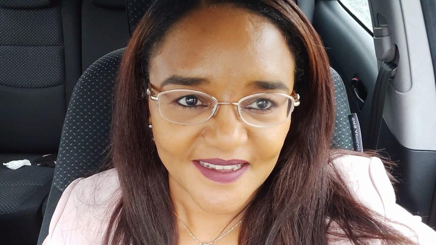 Twasul Mohammed. She has long brown hair, and is wearing glasses and a pink blazer.