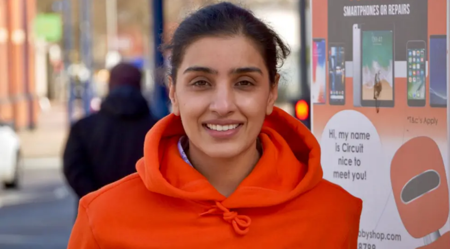 Sun Kaur in Bilston. She is wearing a bright red jumper and smiling.