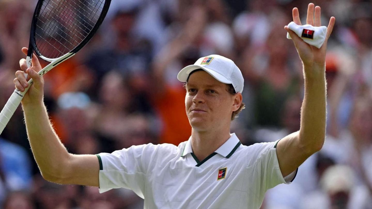 Jannik Sinner waves to the crowd at Wimbledon