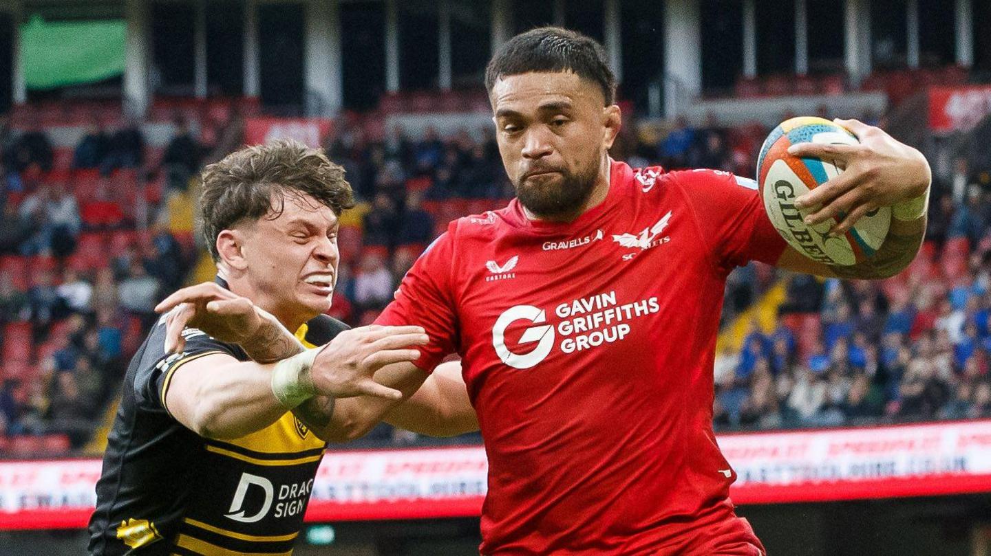 Vaea Fifita holds the ball against Ryan Woodman