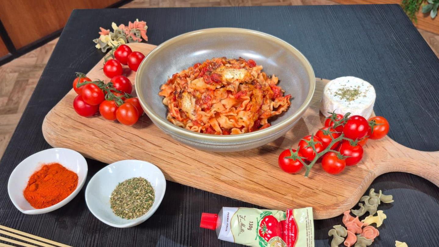 Briony's tomato pasta in bowl alongside its component ingredients including tomatoes, paprika, mixed herbs and tomato paste.