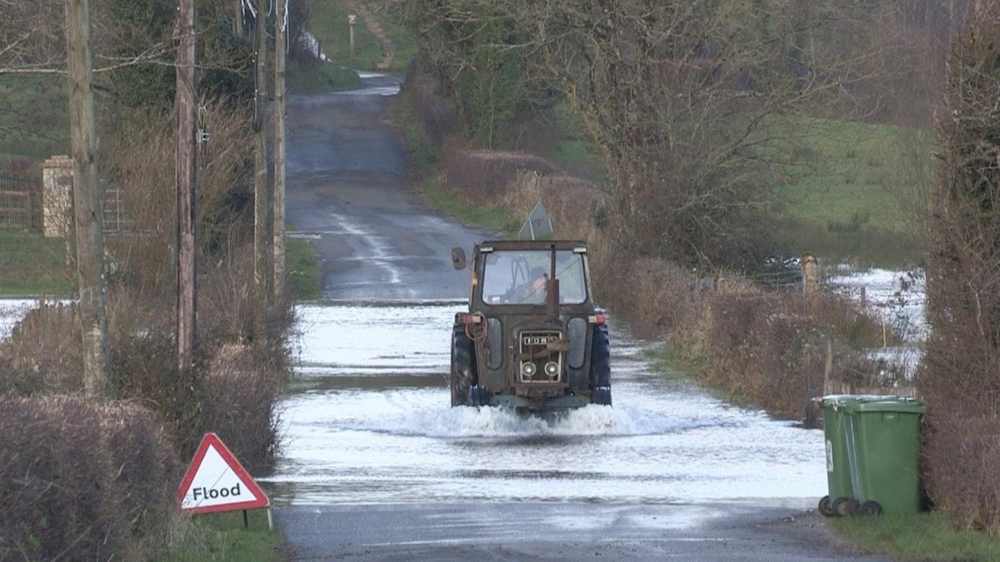 A tractor drives through flooding in Boho