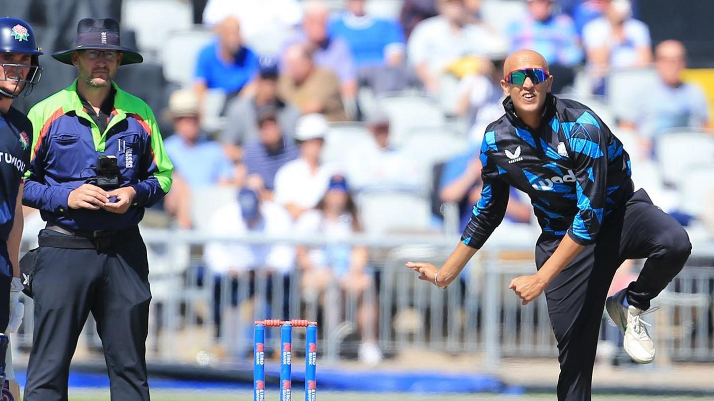 Fateh Singh bowling for Worcestershire in the One-Day Cup under the watching gaze of the umpire, ex-Pears and England spinner Richard Illingworth