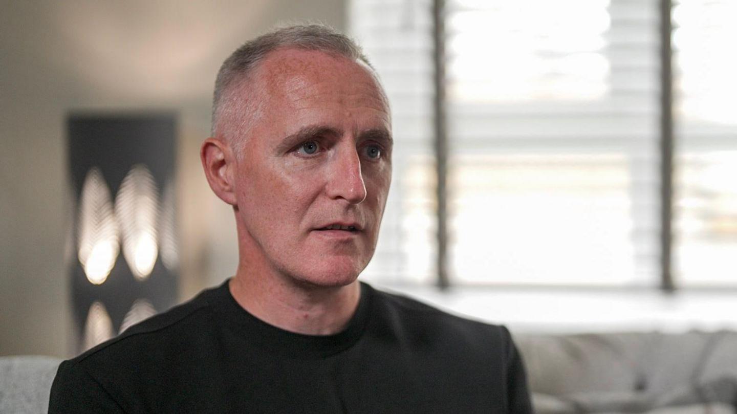 Gerry, who wears a black T-shirt and has short grey hair, speaks to the BBC in his home. 