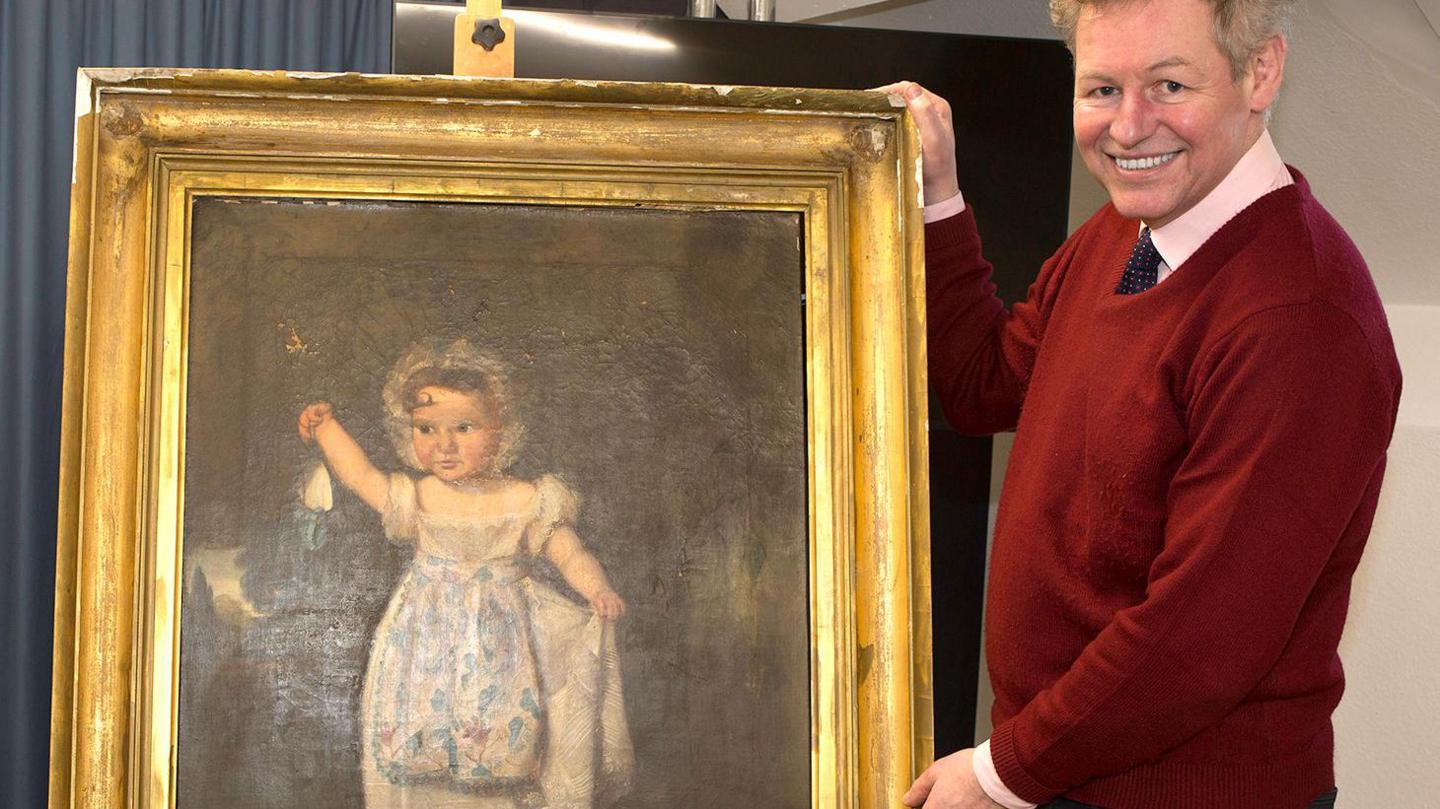 Auctioneer James Laverack with a portrait of Claribel as a young child