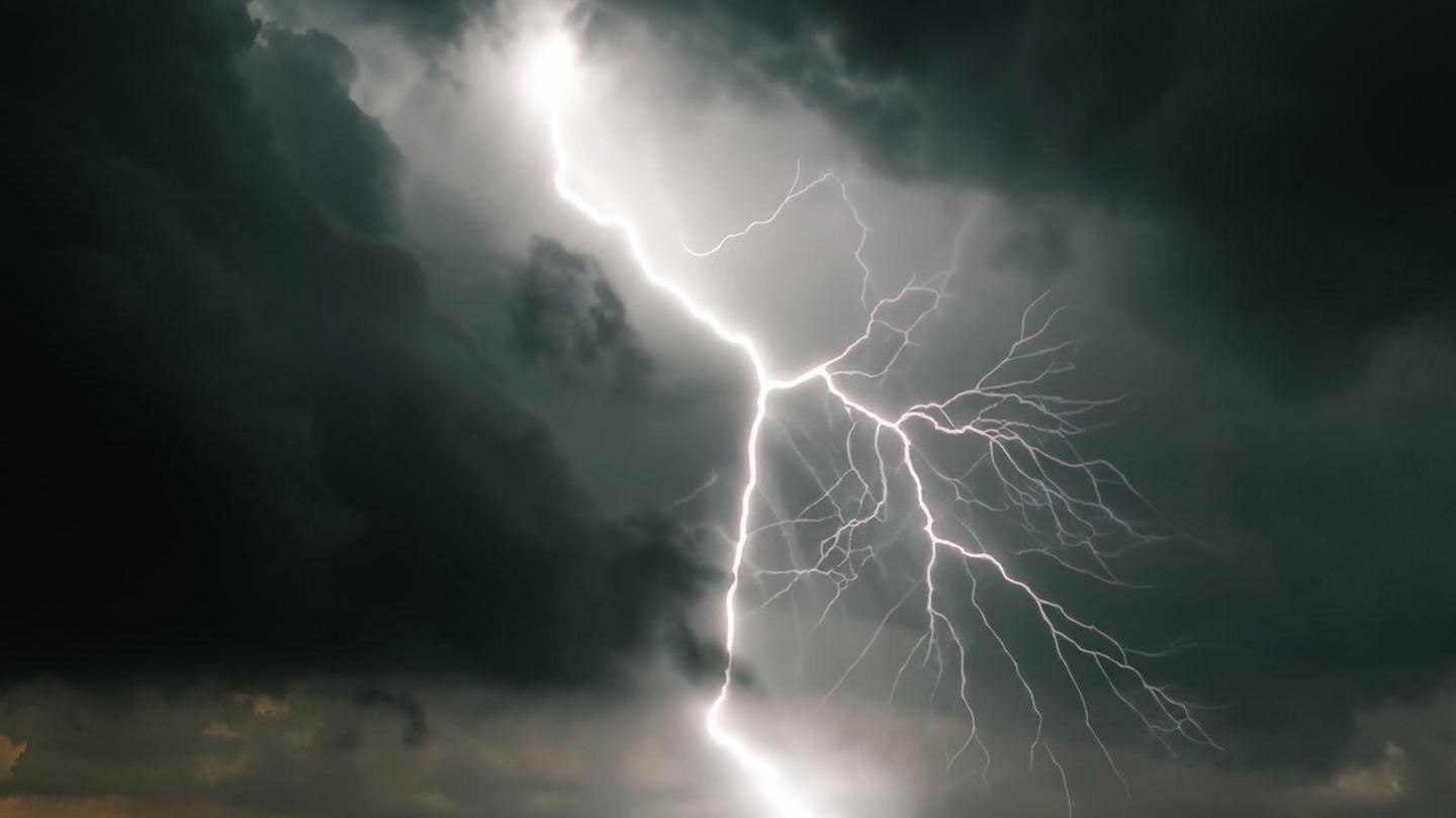 Lighting breaking through darks clouds in the sky.