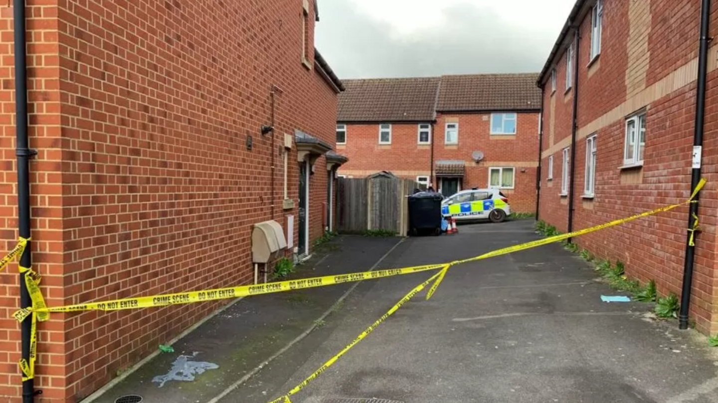 A street with police tape and a police car