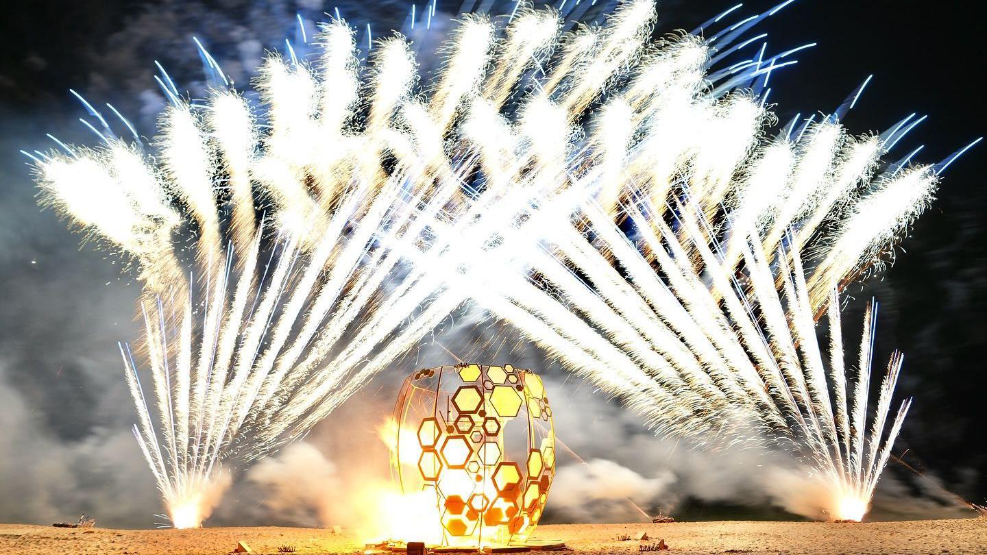 a display called "The Honey Pot" at the East Cliff Zig Zag beach with fireworks behind an artistic pot