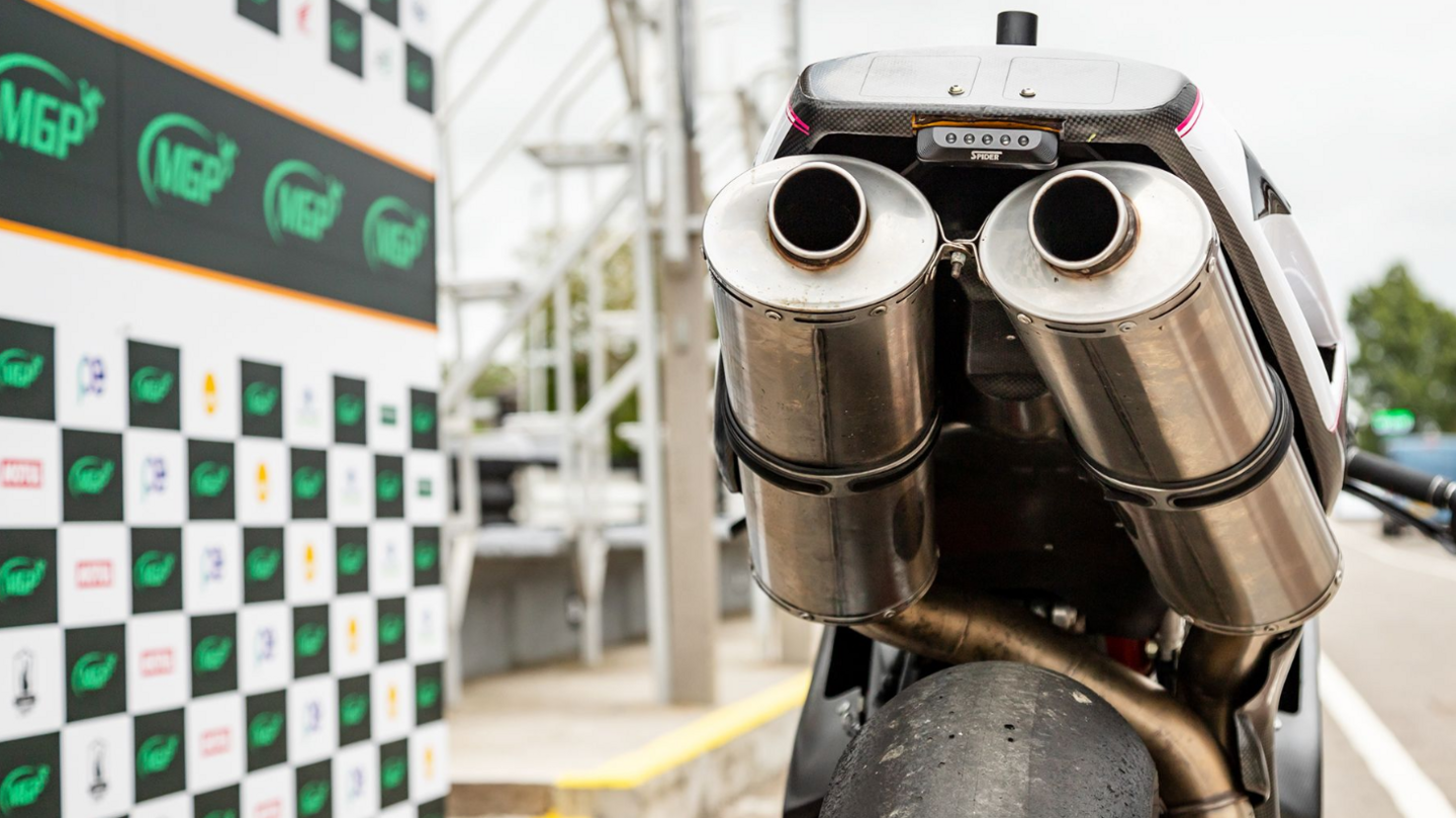 The rear of a racing motorcycle in pit lane with hoardings featuring the MGP logo to the left.