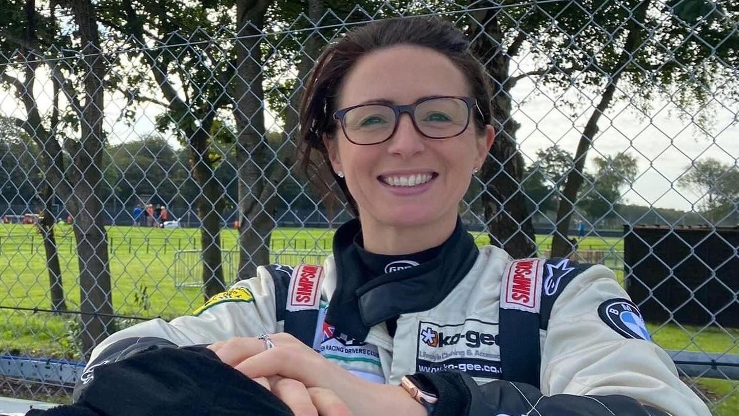 Claire Norman smiling and wearing her racing gear