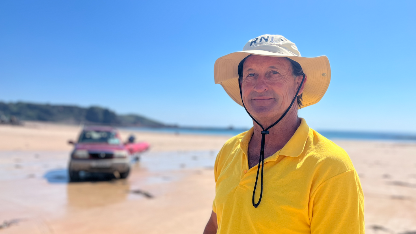 Man in yellow polo shirt and wide brimmed had on a beach