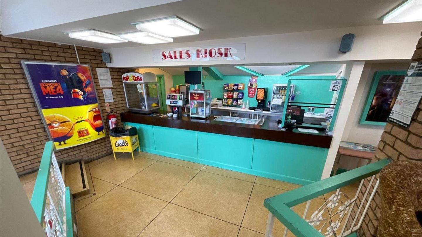 Blue sales kiosk at Hollywood Plaza with popcorn, drinks and snacks machines 