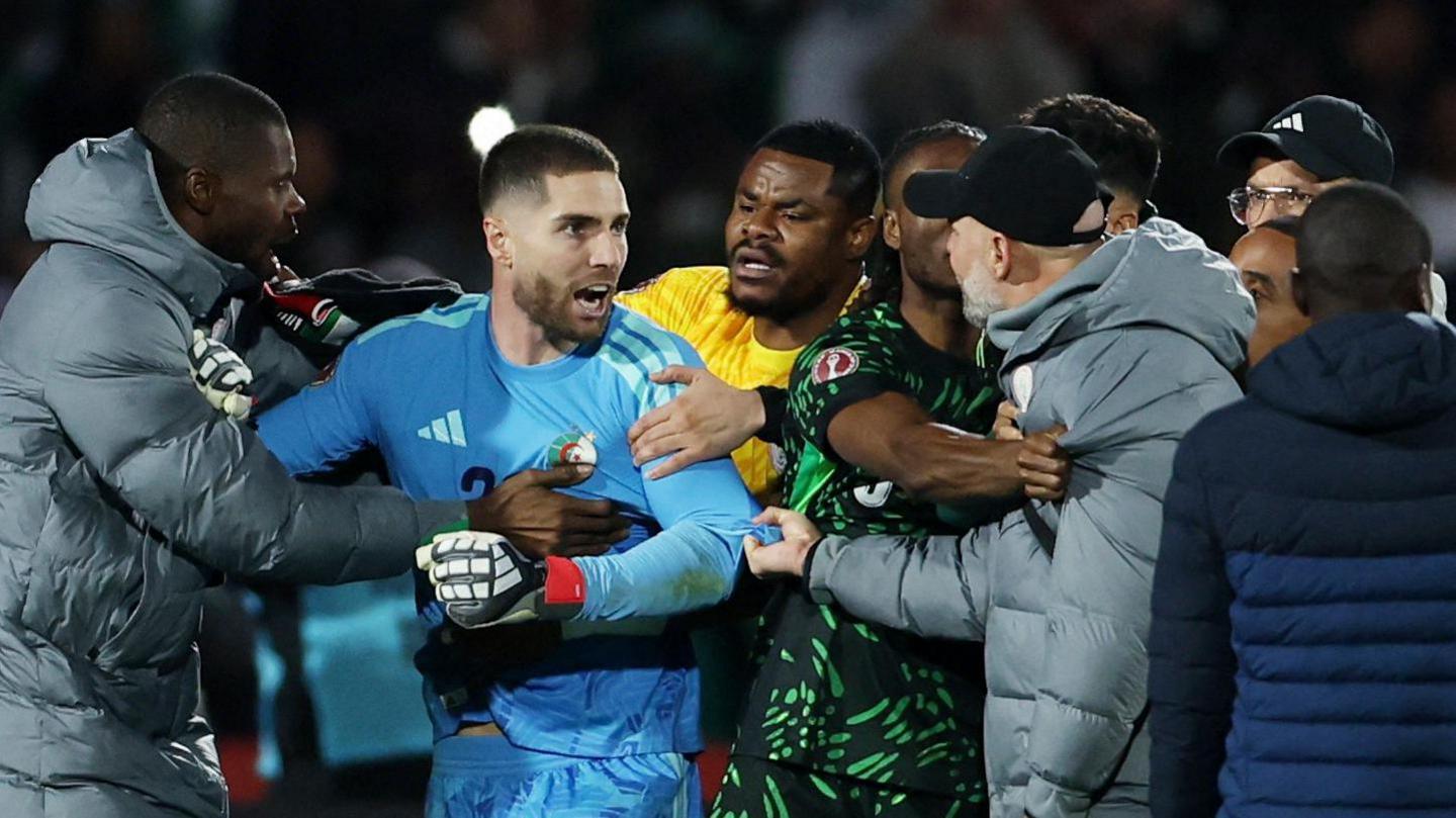 Algeria goalkeeper Luca Zidane (second left) has an angry look on his face as he is pulled away from a confrontation after a football match