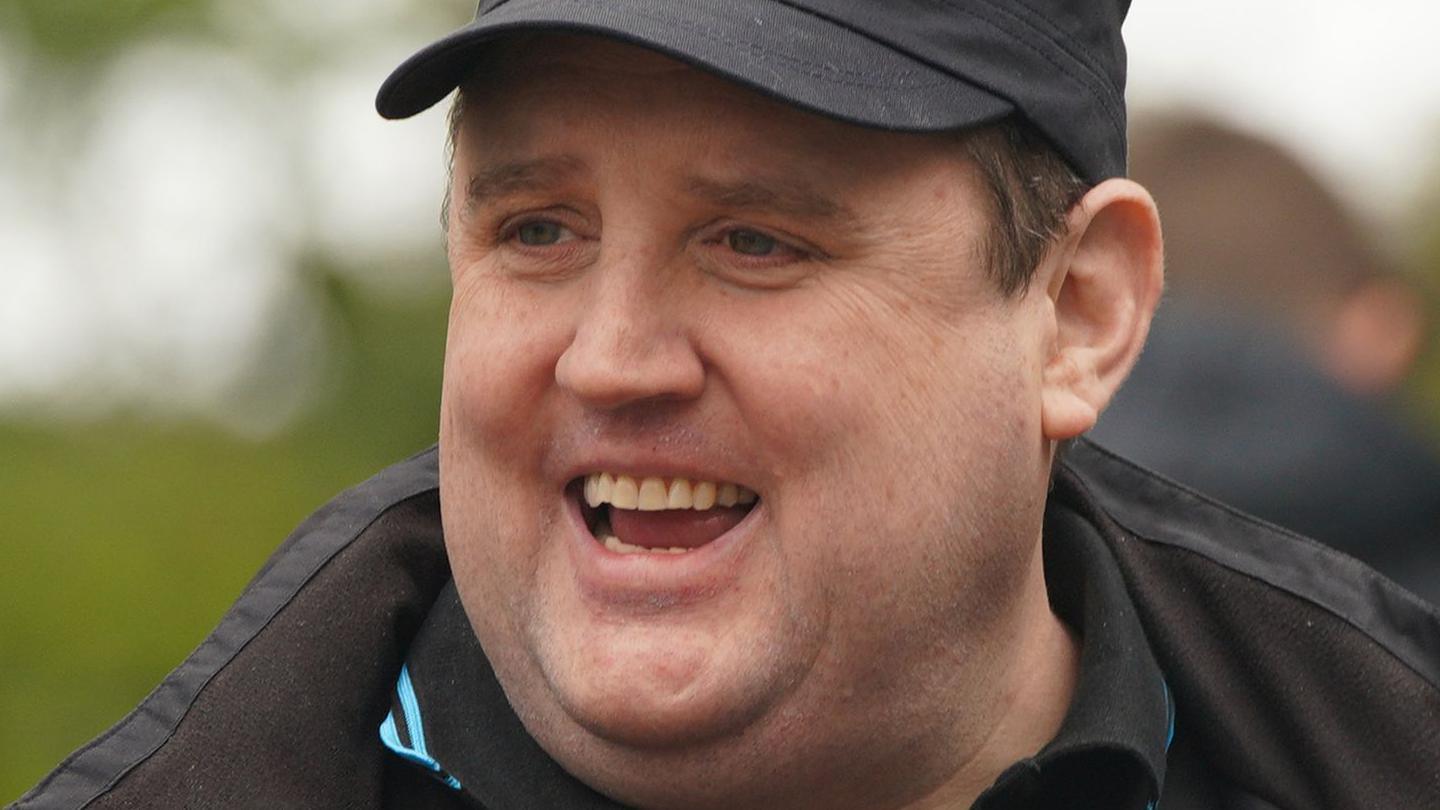 Peter Kay smiling in a baseball cap in 2022