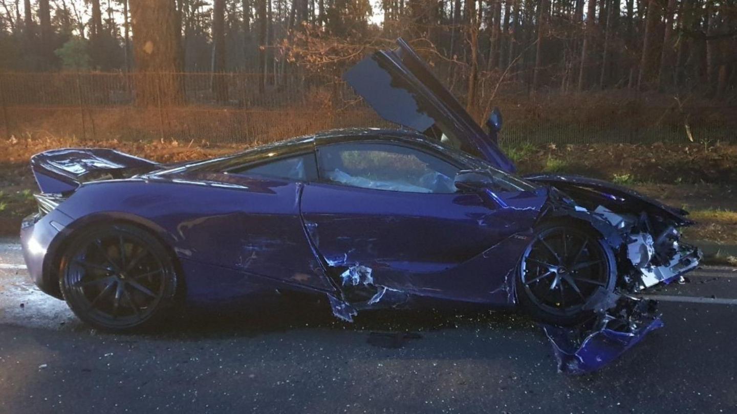 A crashed and badly damaged purple car.