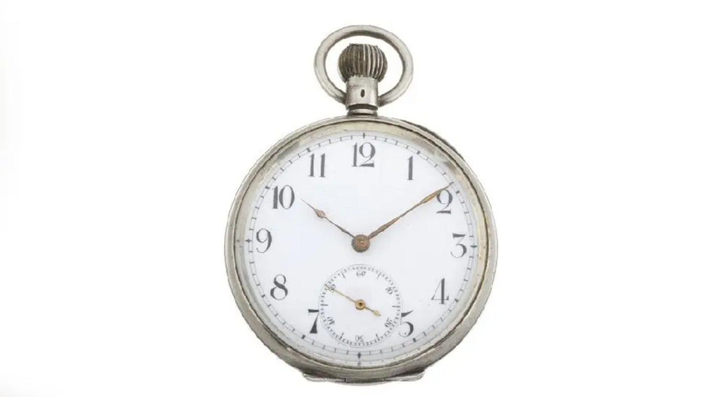 A silver pocket watch from the early 20th century. The hands on the watch tell the time as 10:10.