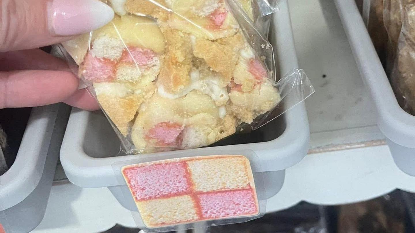 A slice of Battenburg cake in clear plastic packaging. 